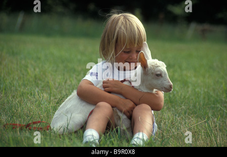 little girl holding baby goat Stock Photo
