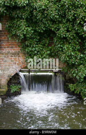 Weir beneath an arch in an ivy clad brick wall on the River Darenth (or Darent) Shoreham Kent UK Stock Photo