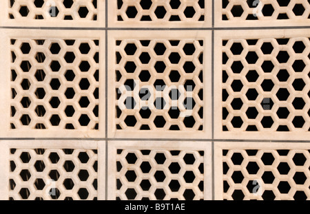 A screen made from polished marble tiles pierced with regular hexagons. Stock Photo
