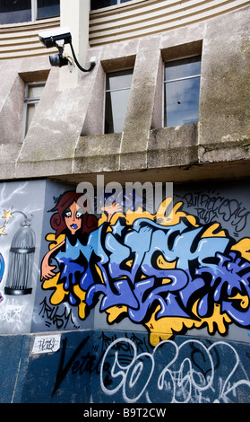 Graffiti on wall within sight of CCTV camera Stock Photo