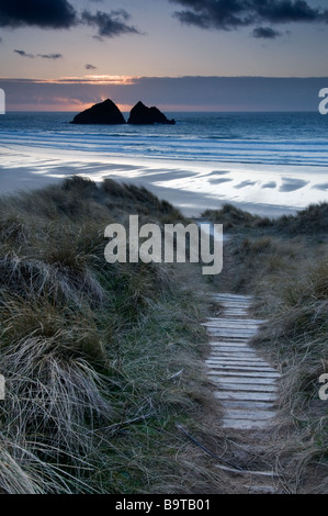 Setting Sun behind Gull Rock on Holywell beach North Cornwall Stock Photo