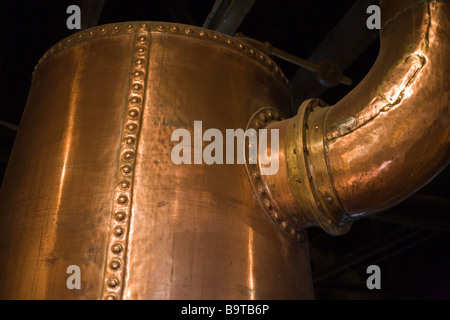 Copper Plumbing. Massive copper distilling pots with riveted piping used in the process of Whiskey making in this old plant. Stock Photo