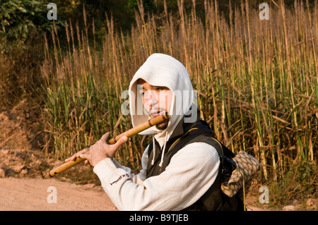 A musician plays his flute out in the nature. Stock Photo