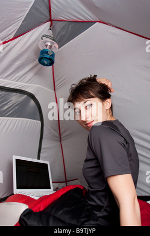 A woman in a tent with an Apple Laptop, Yosemite National Park, Californian, USA