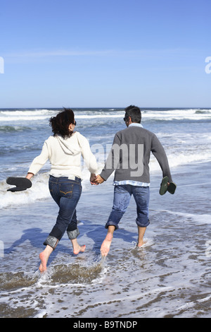 Young couple walking on beach Stock Photo