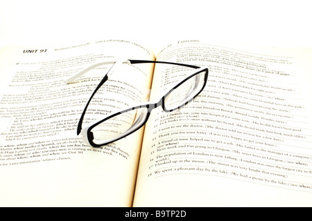 modern glasses on open english studying book Stock Photo