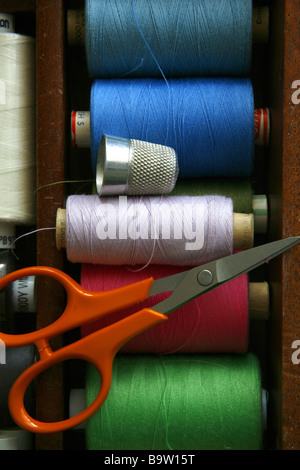 Reels of cotton, a pair of scissors and a thimble. Stock Photo