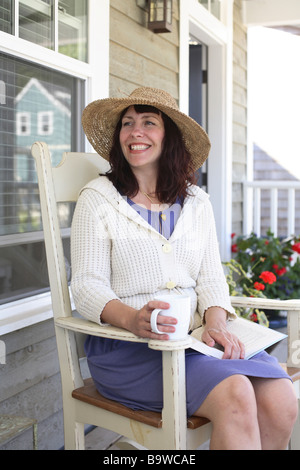 Woman sitting in chair on porch Stock Photo