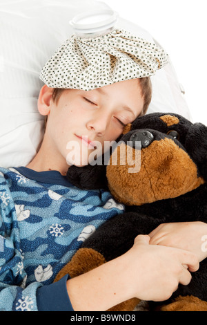 Little boy home sick in bed is sleeping with his stuffed animal  Stock Photo