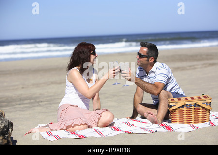 Couple having picnic on beach Stock Photo