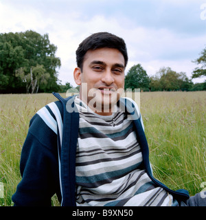 portrait of foreign student studying at a university in London, UK smiling, relaxed in Richmond Park, sunny afternoon Stock Photo