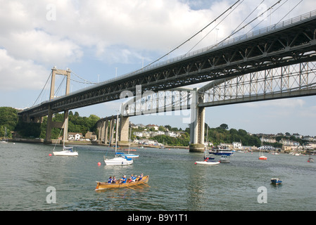 Gig boat racing below the Tamar Bridge and Brunel's Royal Albert Bridge, Saltash, Cornwall, UK Stock Photo