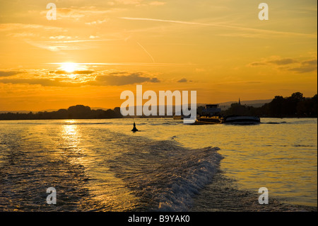 Powerboat wake and cargo ships in sunset on Rhine river | Germany Heckwelle eines Motorbootes und Frachtschiffe auf den Rhein Stock Photo