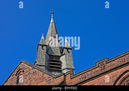 Looking up toward the spire at St Andrews Church in West Kirby on a sunny day with blue sky Stock Photo