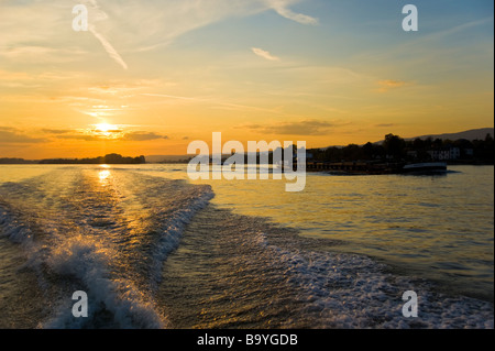 Powerboat wake and cargo ships in sunset on Rhine river | Germany Heckwelle eines Motorbootes und Frachtschiffe auf den Rhein Stock Photo