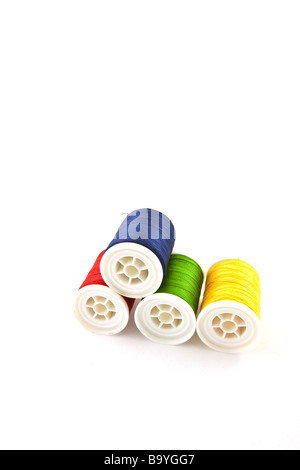 four multicolored spools on a white background Stock Photo