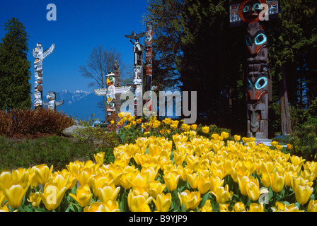 Totem Poles and Spring Flowers at Brockton Point in Stanley Park Vancouver British Columbia Canada Stock Photo