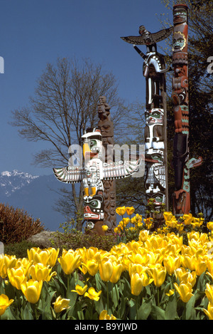 Stanley Park, Vancouver, BC, British Columbia, Canada - Totem Poles and Spring Flowers at Brockton Point Stock Photo