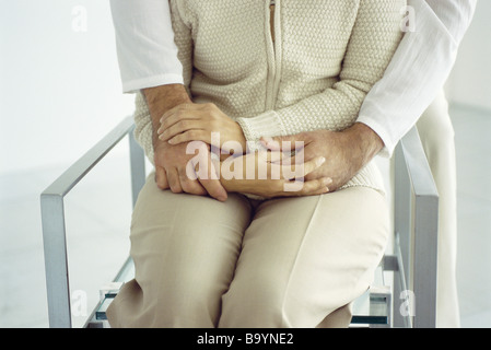 Woman sitting, man embracing from behind, cropped Stock Photo