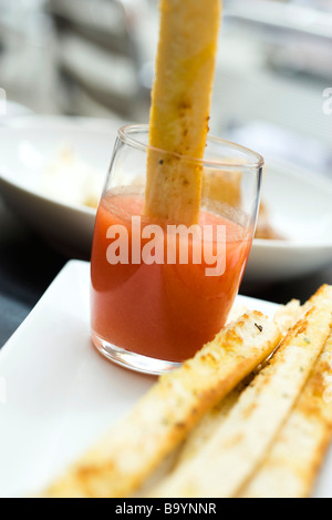 Breadstick dipped in spicy sauce Stock Photo