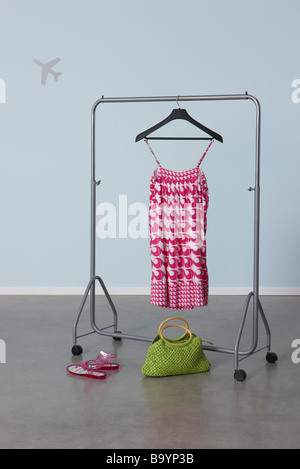 Summery woman's outfit on clothes rack, plane image in background Stock Photo