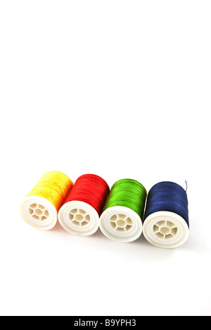 four multicolored spools on a white background Stock Photo