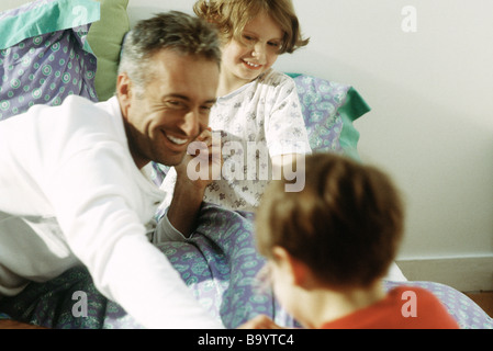 Family together on bed, smiling Stock Photo