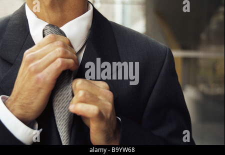 Man adjusting tie, cropped Stock Photo