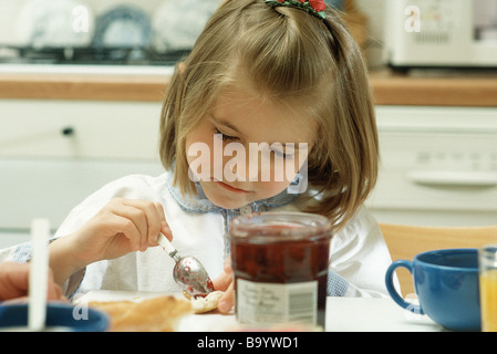 Girl putting jam on bread Stock Photo