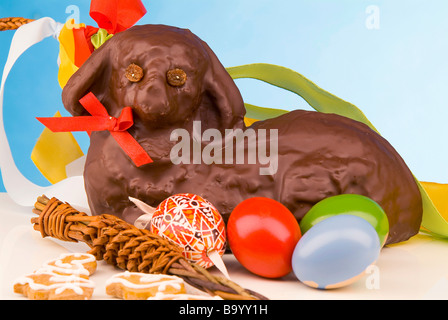 Still life of Easter lamb with chocolate icing painted eggs and whipping cane Stock Photo