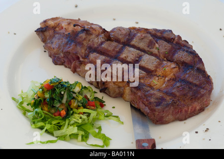 Detail of a juicy prime rib entrecote steak with vegetable salad Stock Photo