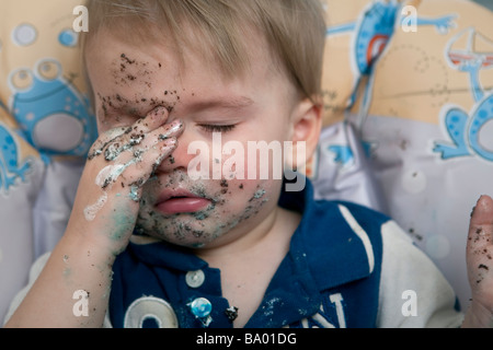 Young boy at a birthday party covered and on the verge of falling asleep. Stock Photo