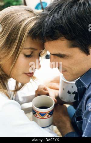 Couple touching foreheads over coffee Stock Photo