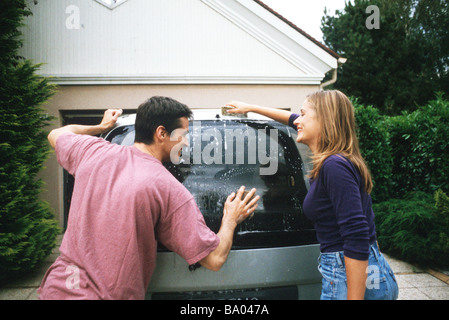 Couple washing car together Stock Photo
