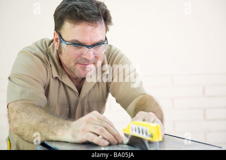 Handsome tile cutter using table saw to cut ceramic tile  Stock Photo