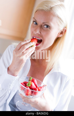 Mature Woman Eating Strawberries Stock Photo - Alamy