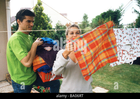 Couple hanging up laundry on clothes-line Stock Photo