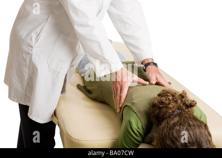 Chiropractor doing adjustment on female patient White background  Stock Photo