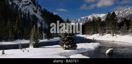 Panorama of Madison River in winter with men fly fishing with snow covered Rocky mountain Madison Range Montana Stock Photo