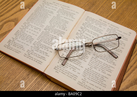 A pair of reading glasses resting on a book of Longfellow poems. Stock Photo