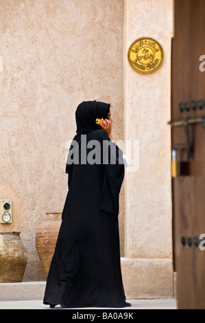 Emirati woman talking on her mobile phone in the Bastakia area Dubai Stock Photo