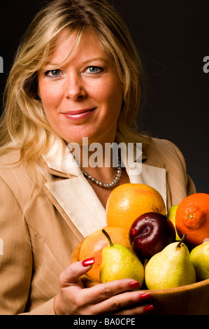 pretty attractive woman smiling suit bowl of fresh fruit Stock Photo