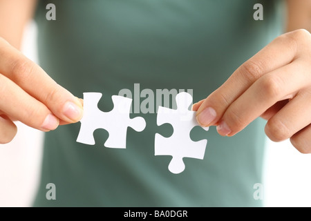 Hands holding two matching puzzle pieces Stock Photo