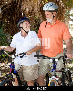 Active senior couple with their bicycles looking lovingly at each other  Stock Photo