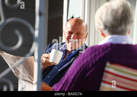 Senior couple having coffee on front porch Stock Photo
