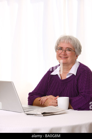 Senior woman with laptop and morning coffee Stock Photo