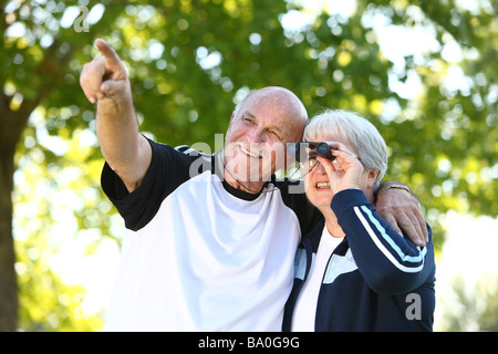Senior couple looking through binoculars Stock Photo