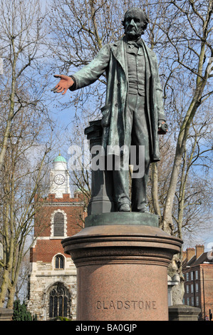 Historical statue commemorating William Gladstone outside The Church of St Mary Bow hands daubed with red paint Tower Hamlets East London England UK