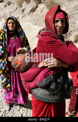 Tajik women with baby wearing traditional dress and hat, Marguzor Lakes, Fan Mountain, Tajikistan, Central Asia Stock Photo