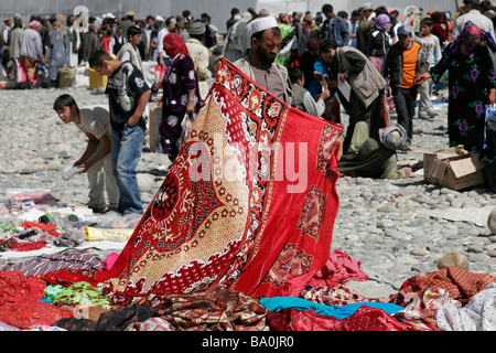 Afghan carpet seller on the transborder market near Ishkashim on the border between Tajikistan and Afghanistan Stock Photo